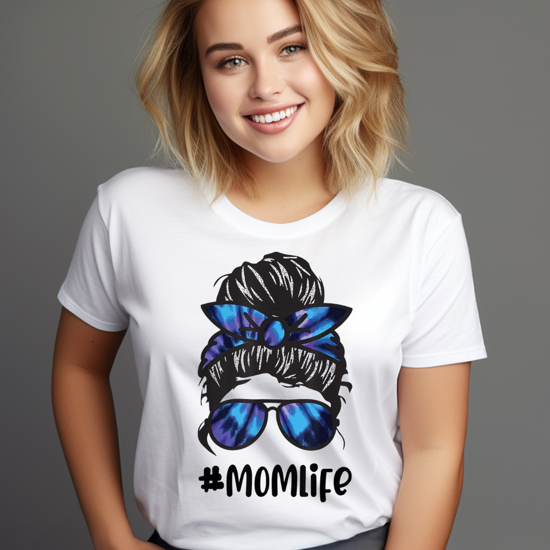 Woman wearing a white casual mom life shirt with #MOMLIFE graphic and blue sunglasses design