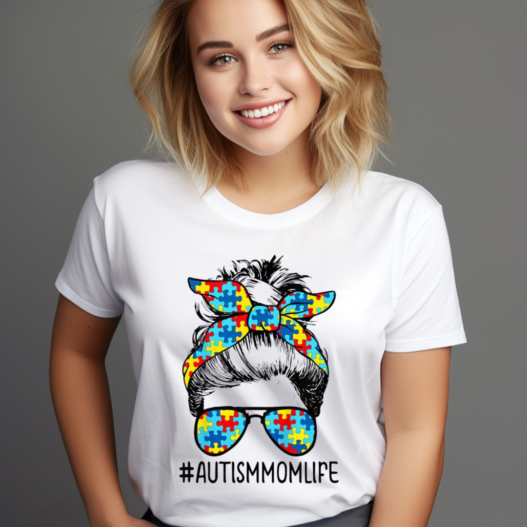 Woman wearing a white messy bun autism shirt with colorful puzzle piece design and hashtag AutismMomLife