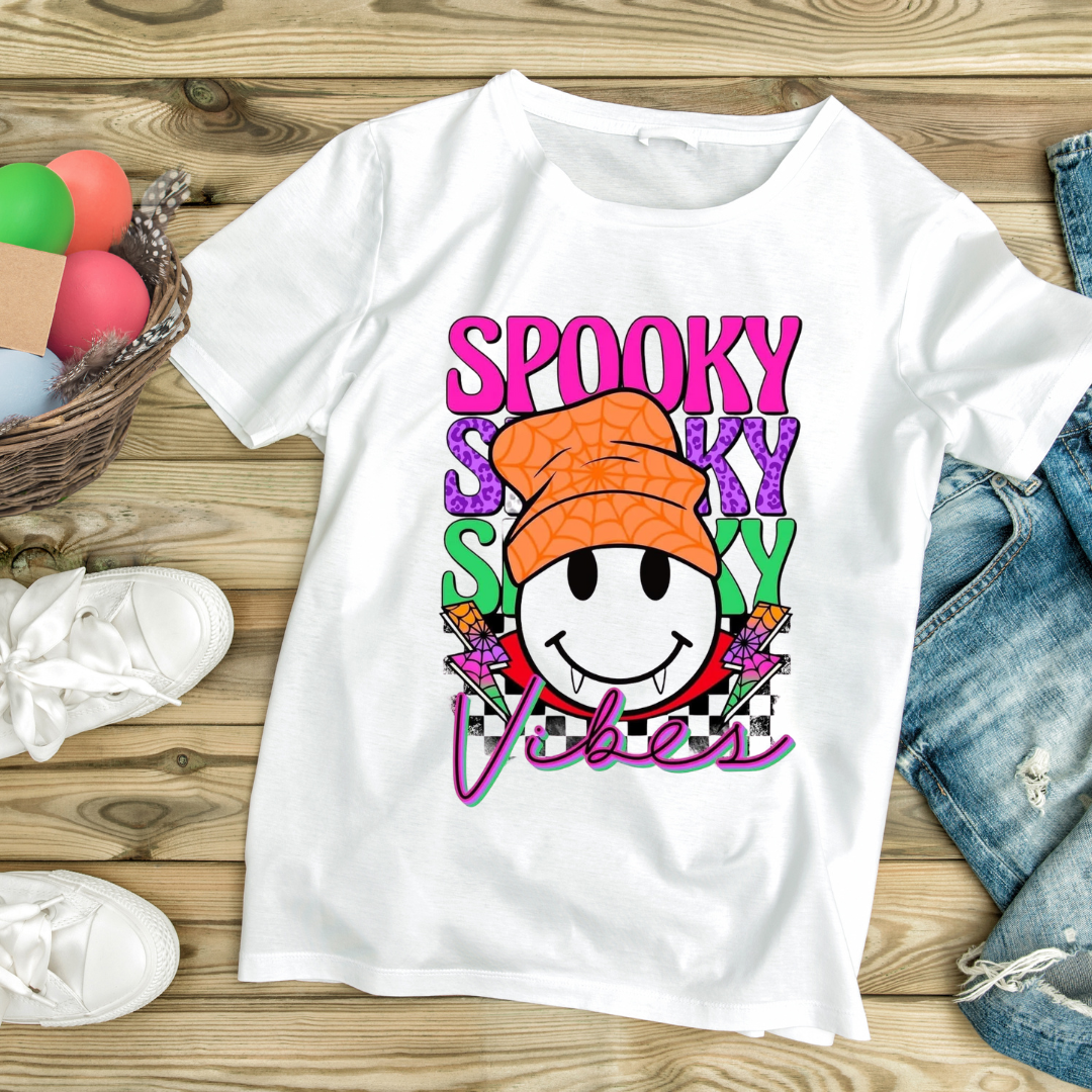 White fun Halloween graphic tee with colorful spooky vibes smiley face wearing an orange hat