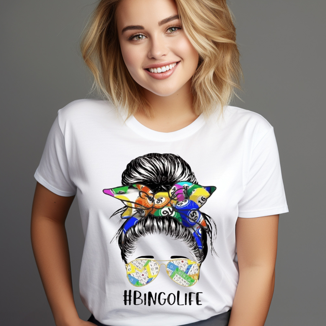 Smiling woman wearing a white Messy Bun Bingo T-shirt with colorful bingo-themed hair scarf and sunglasses design