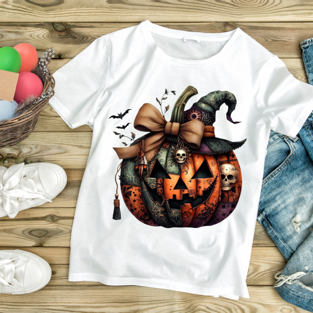 White t-shirt with detailed Halloween pumpkin design featuring bats, skulls, and a witch hat