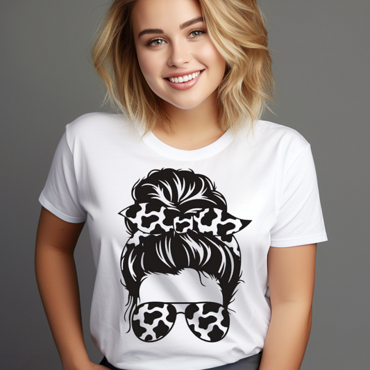 Woman wearing a white cow print messy bun shirt with black cow print sunglasses and hair bow design