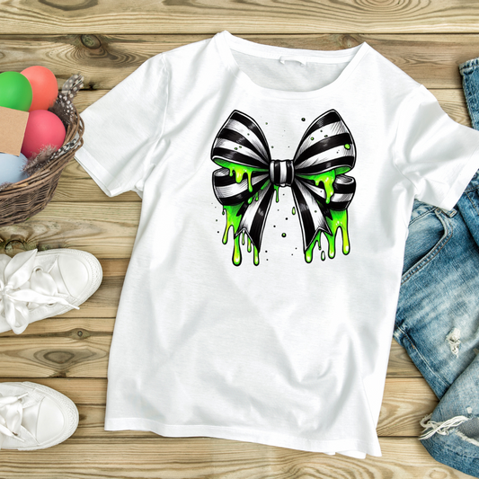 White t-shirt featuring a custom graphic slime bow shirt design with black and white striped bow and green slime dripping