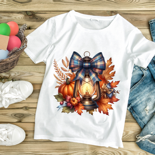 White custom Halloween t-shirt featuring a lantern with a plaid bow surrounded by pumpkins and autumn leaves