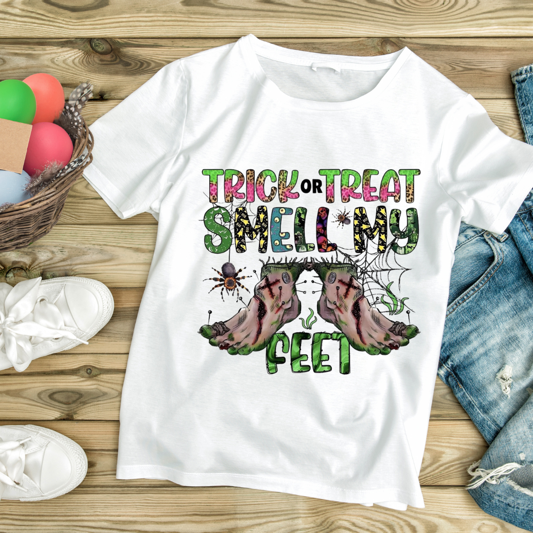 White Halloween t-shirt with Trick or Treat Smell My Feet design featuring spiders and zombie feet customizable Halloween apparel