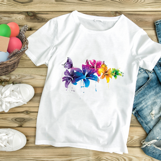 White flower butterfly graphic tee with colorful floral and butterfly design laid flat on wooden surface