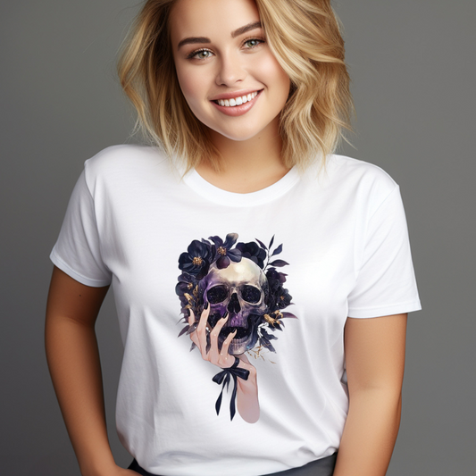 Smiling woman wearing a white holding skull graphic tee with a floral skull and hand design