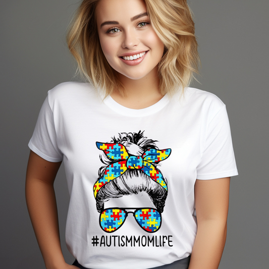 Woman wearing a white messy bun autism shirt with colorful puzzle piece design and hashtag AutismMomLife
