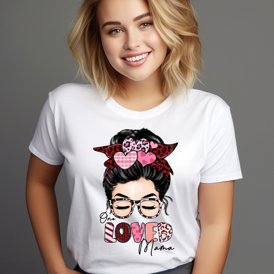 Smiling woman wearing a white one loved mama t-shirt with graphic of a woman’s face and hearts
