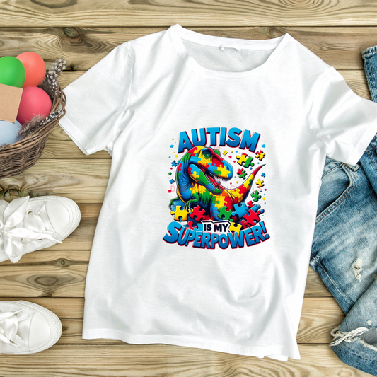 White superpower autism t-shirt with colorful puzzle piece dinosaur design on wooden background