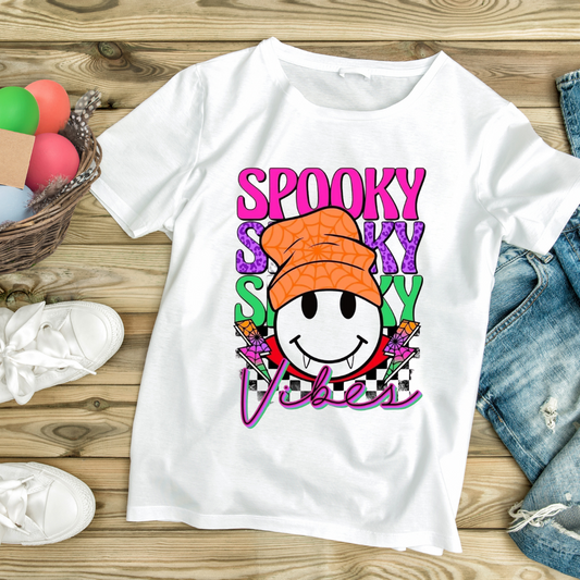 White fun Halloween graphic tee with colorful spooky vibes smiley face wearing an orange hat