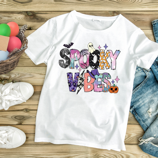 White t-shirt with colorful Halloween-themed Spooky Vibes graphic from Customizable Creations